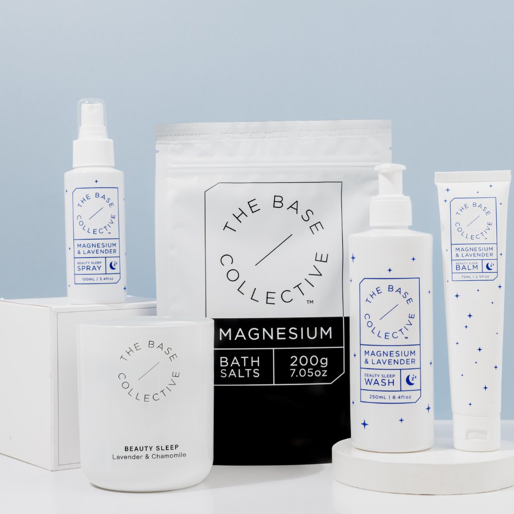 Magnesium for sleep bundle collection including Magnesium Spray for sleep, Scented Soy Candle, Magnesium Salts, Magnesium Body Wash and Magnesium lotion on with plate.