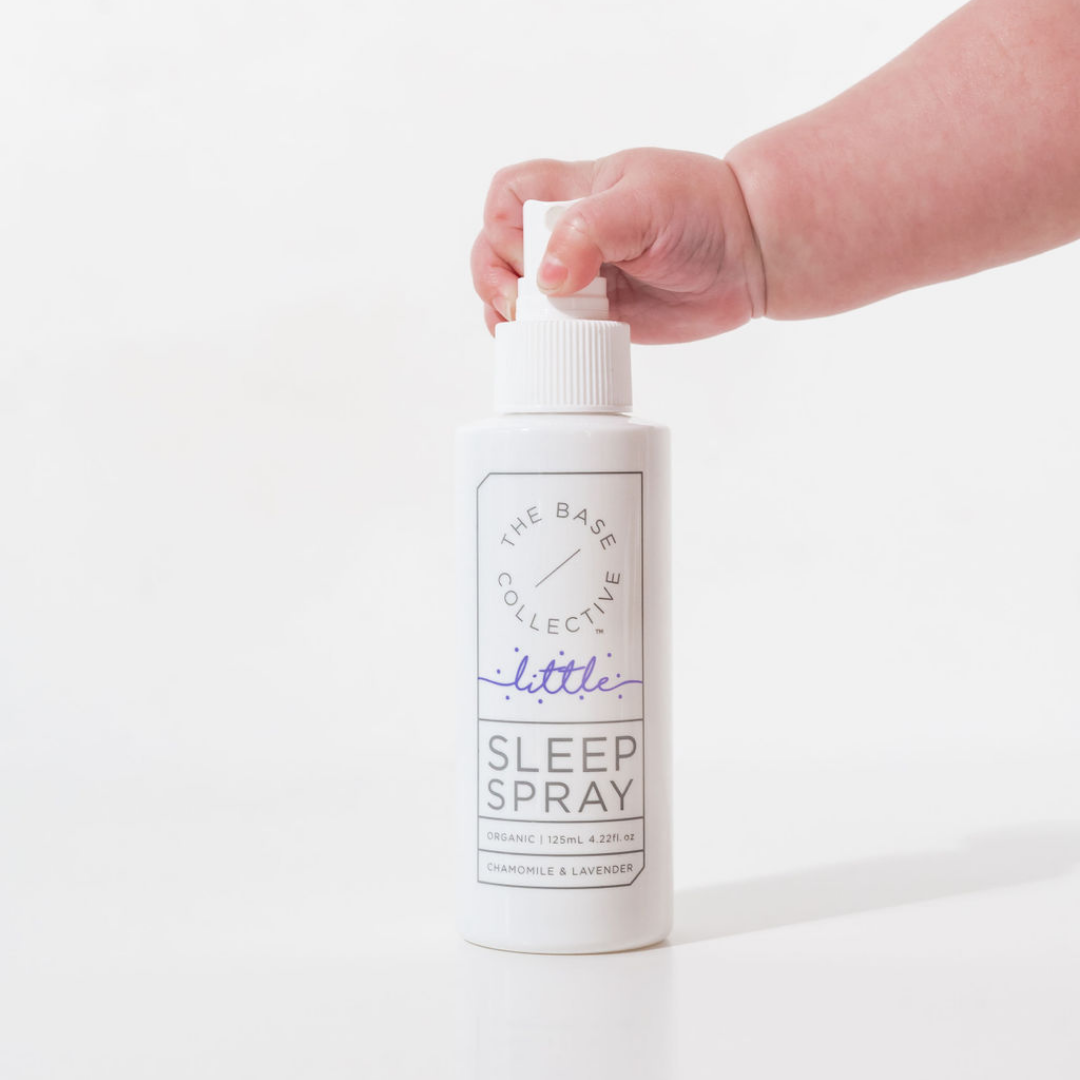 Little Lavender sleep spray with baby hand in against a white back ground.