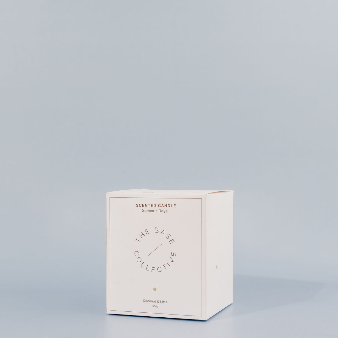 Coconut & Lime Scented Soy Candle by The Base Collective front of Box with light blue background. 