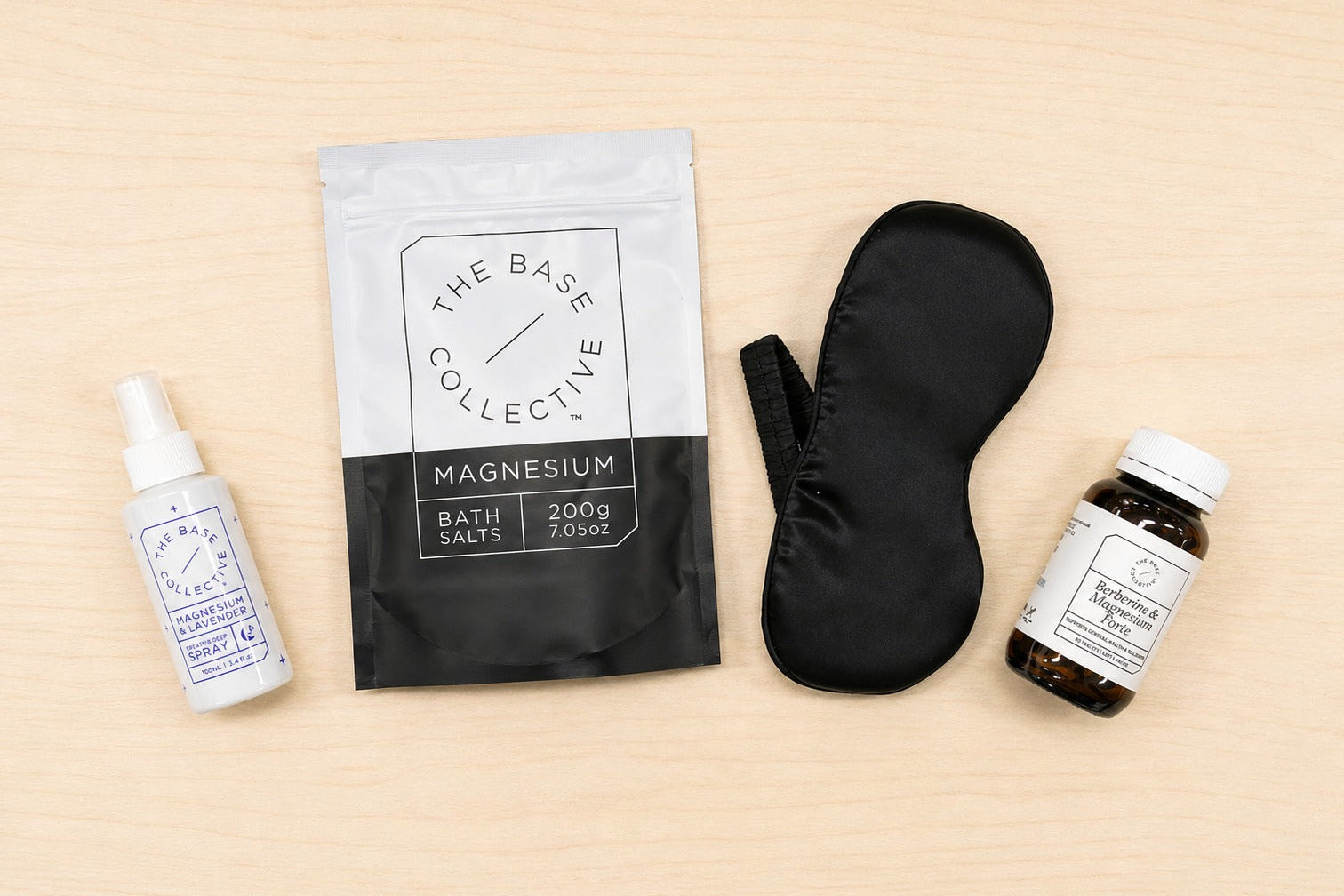 Collection of wellness products including a spray bottle, bag, eye mask, and jar on a beige background.